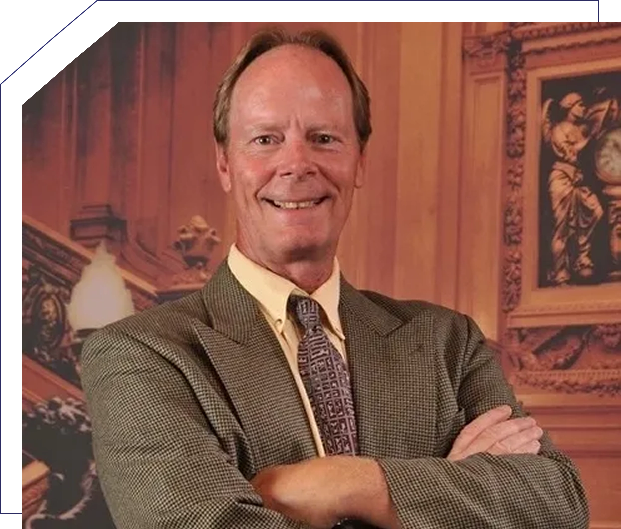Smiling man in suit with crossed arms.